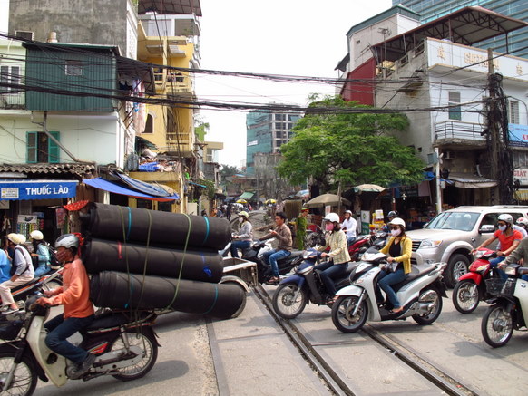 A constant stream of motorbikes makes crossing a difficult task